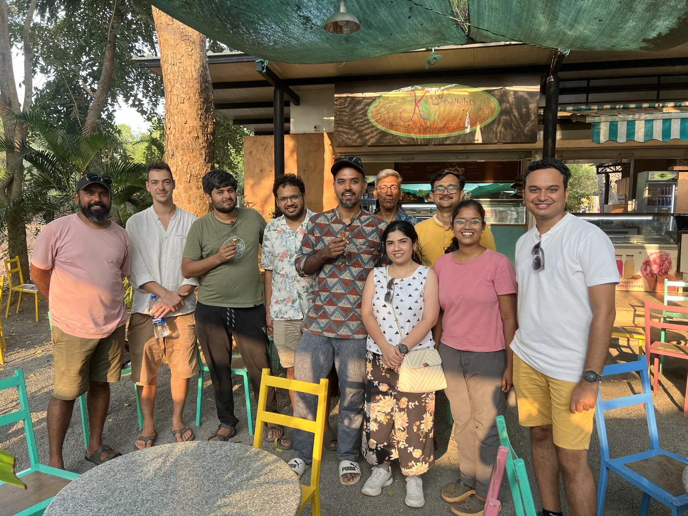 A group photo of ten retreat participants. They are standing in front of an outdoor bar and smiling at the camera.