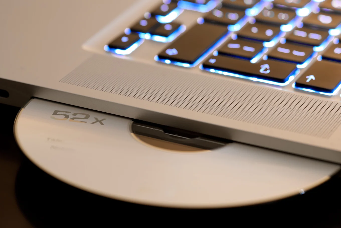 Laptop keyboard, ejecting disc labeled "52x".