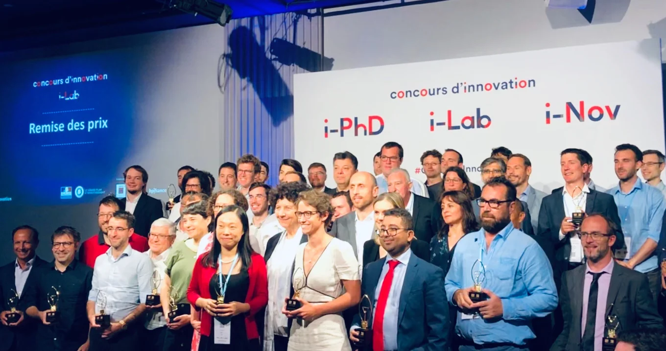 Group photo, people holding trophies, "concours d'innovation" text.