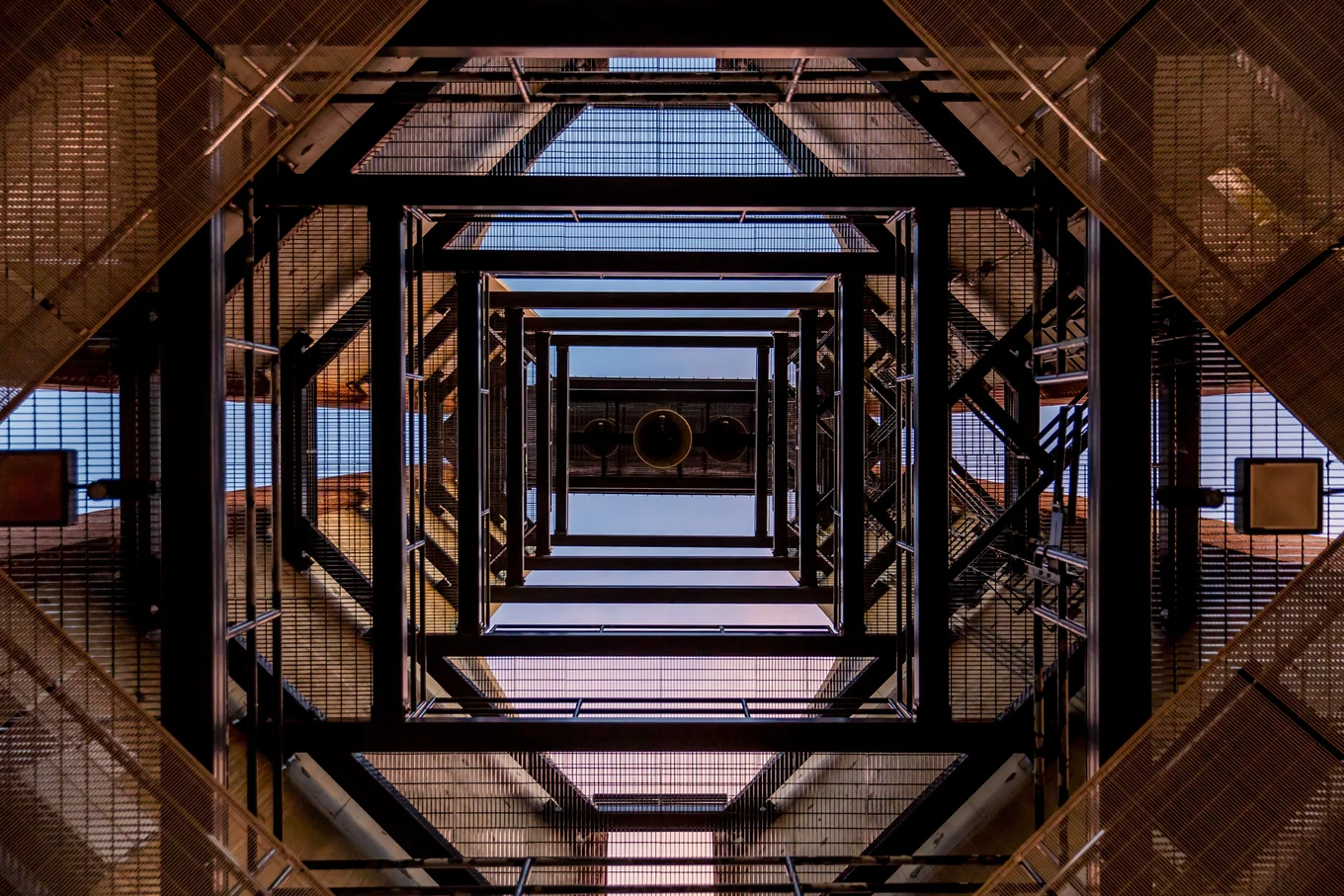 Square metal framework with blue sky background.