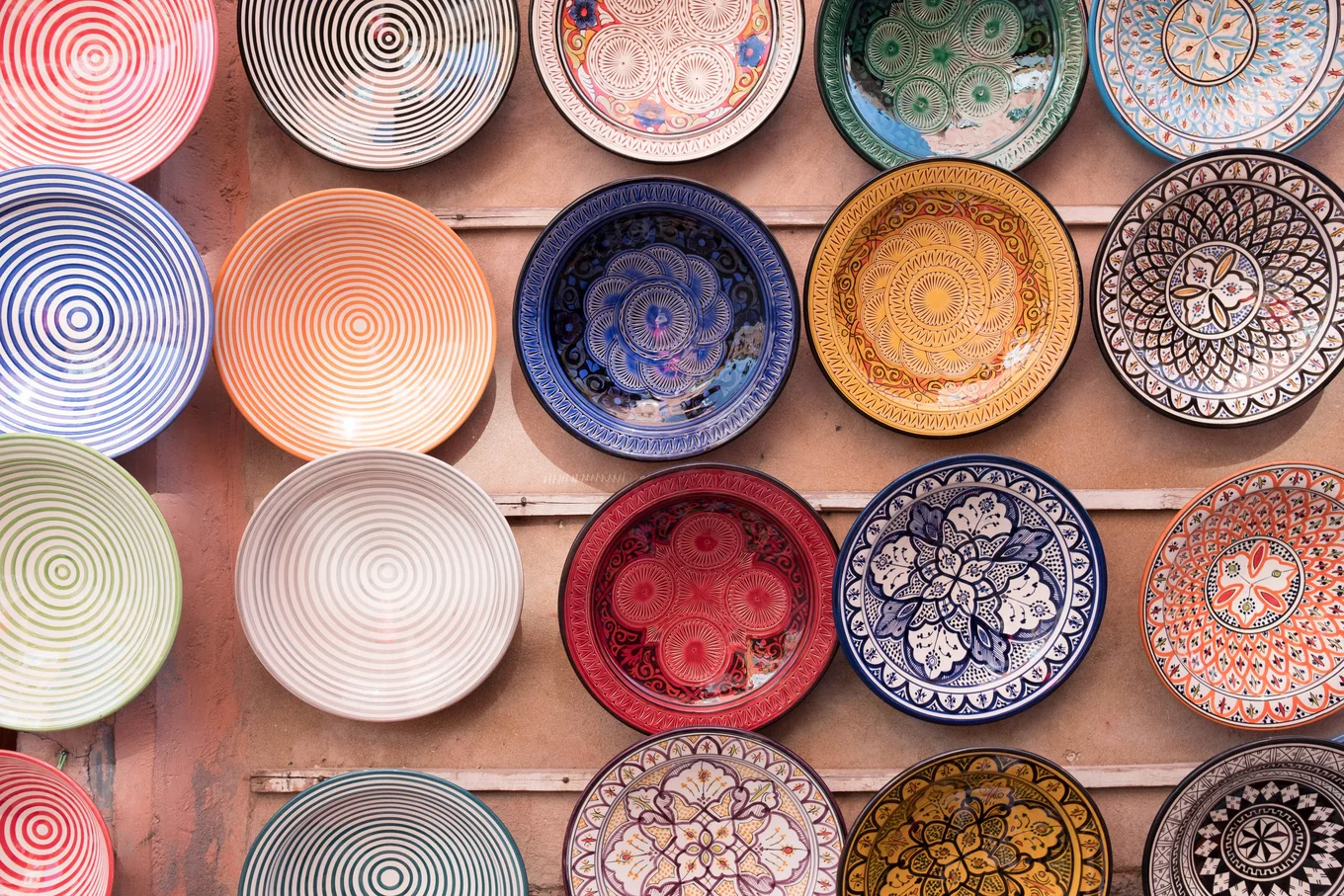 Colorful patterned ceramic plates on a wall.