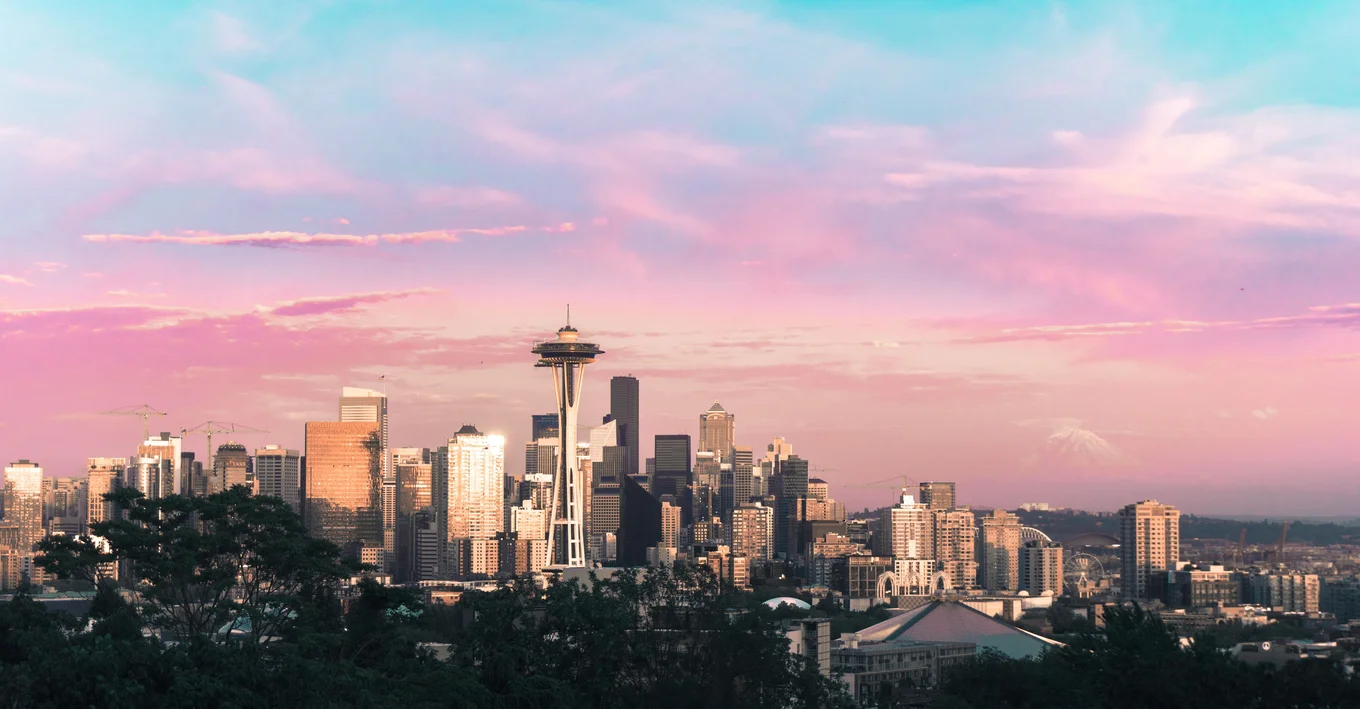 City skyline with iconic tower, pinkish sky.