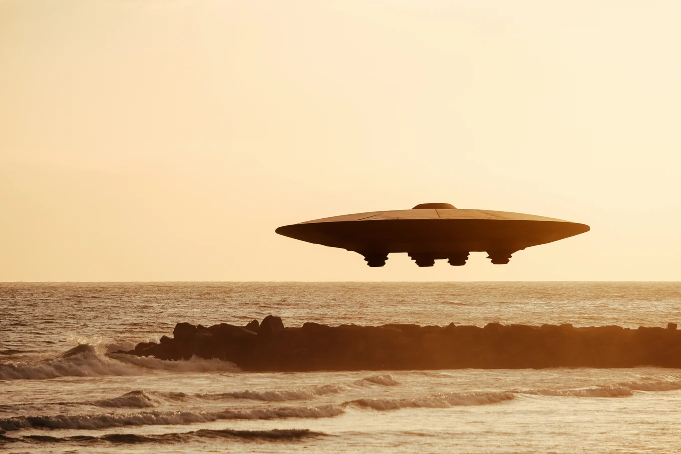 UFO hovering over the ocean at sunset.